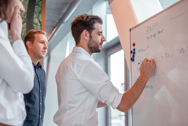 Luca tekent op een whiteboard tijdens een daily standup