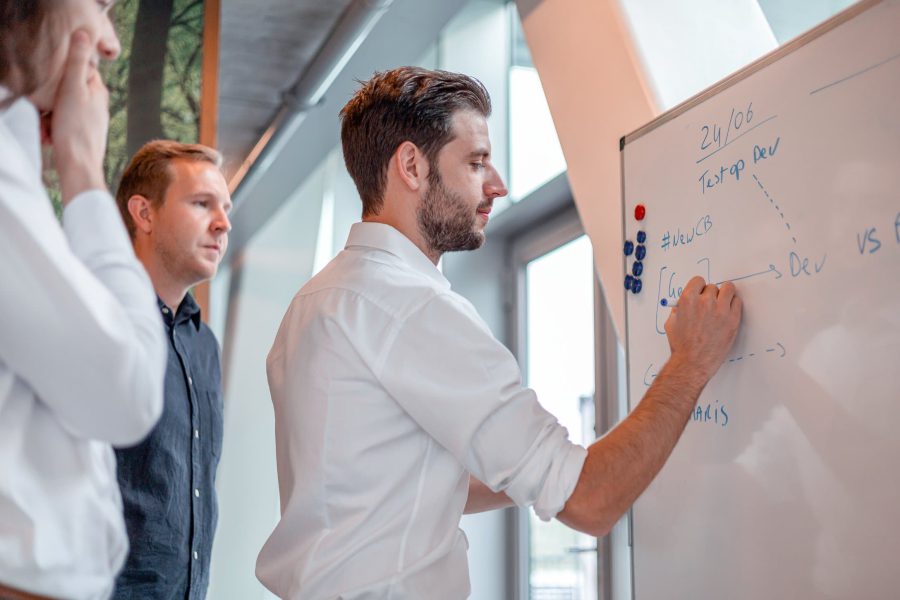 Luca tekent op een whiteboard tijdens een daily standup