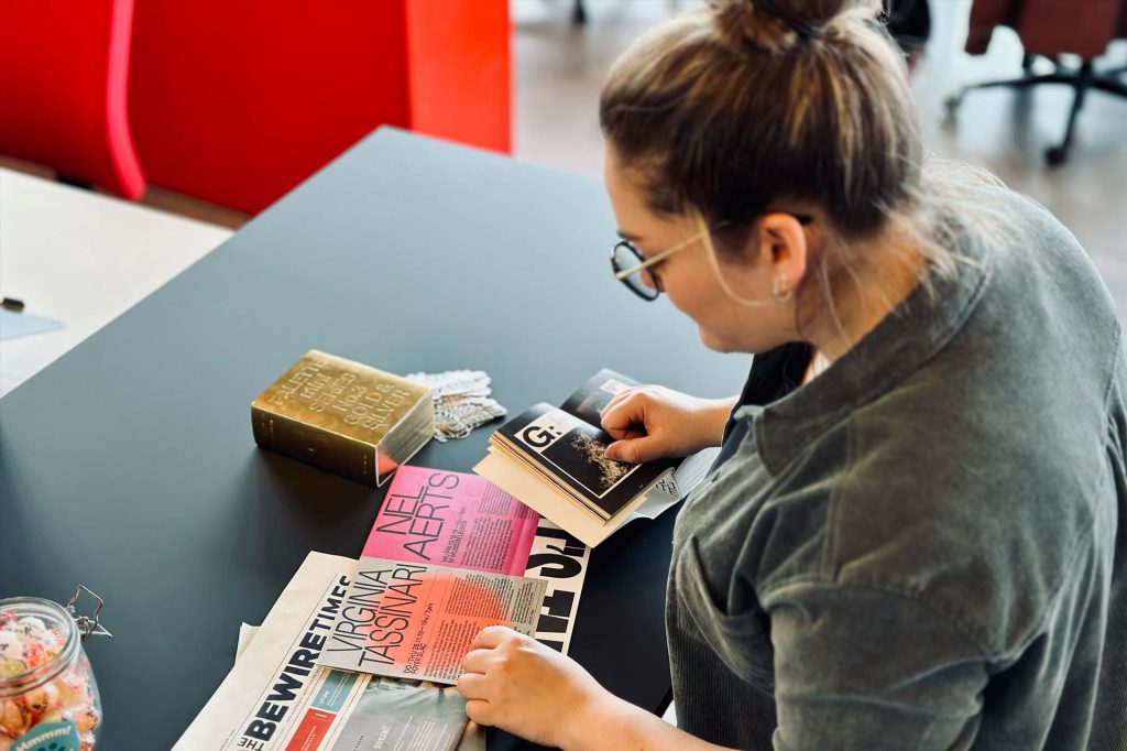 Theriessa bekijkt enkele voorbeelden en stalen van drukwerk