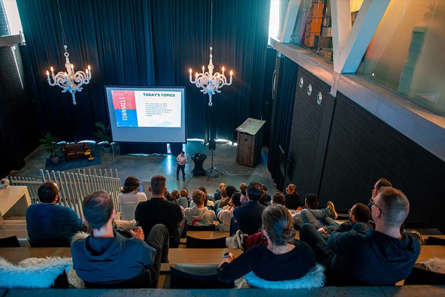 Jeroen Benats, Managing Partner van Bewire presenteert tijdens een Townhall van Bewire in een gevulde zaal